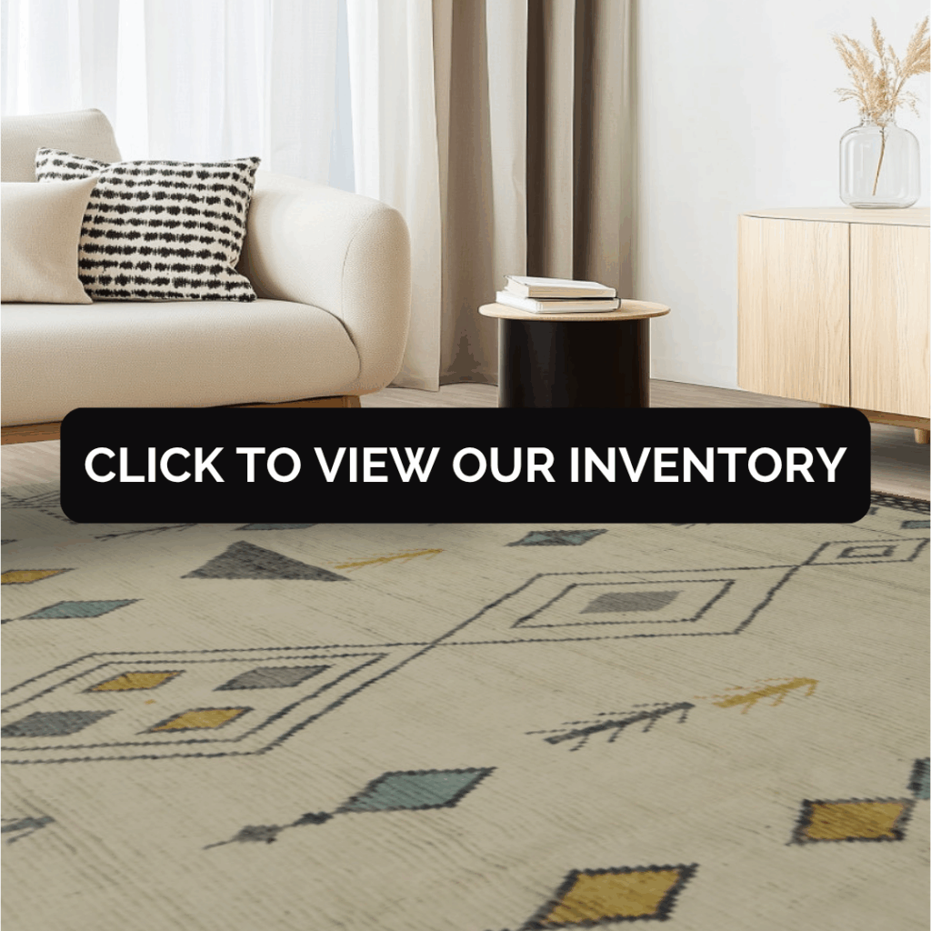A modern neutral-toned living room with a cream sofa, black round table, and a rug patterned with light gray lines and diamond shapes accented in yellow and teal.