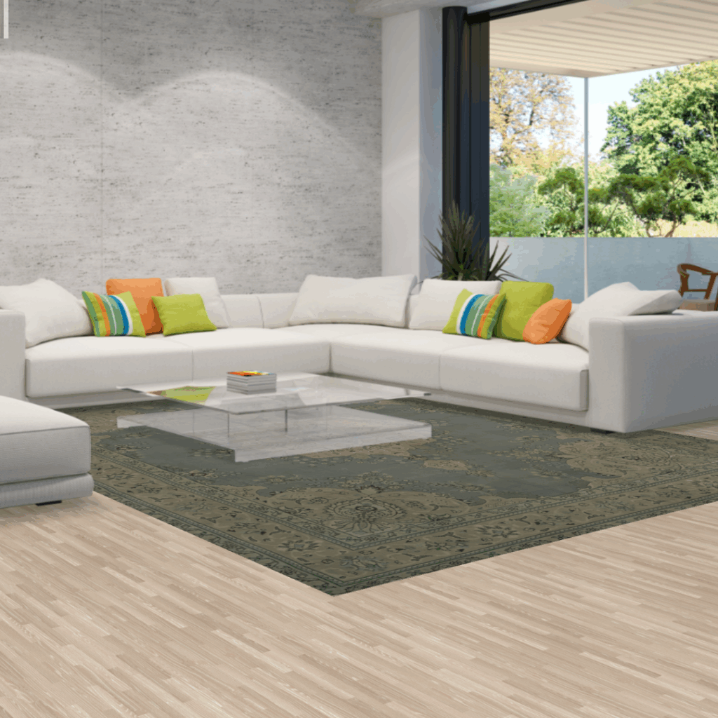 A modern living room with a large white sectional sofa, colorful throw pillows, and a muted green patterned rug beneath a glass coffee table, opening to a garden view.